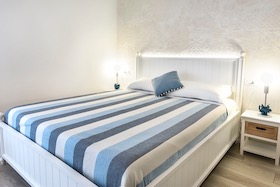 Letto matrimoniale con parete in calce cruda
