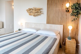 Letto matrimoniale con parete in calce cruda